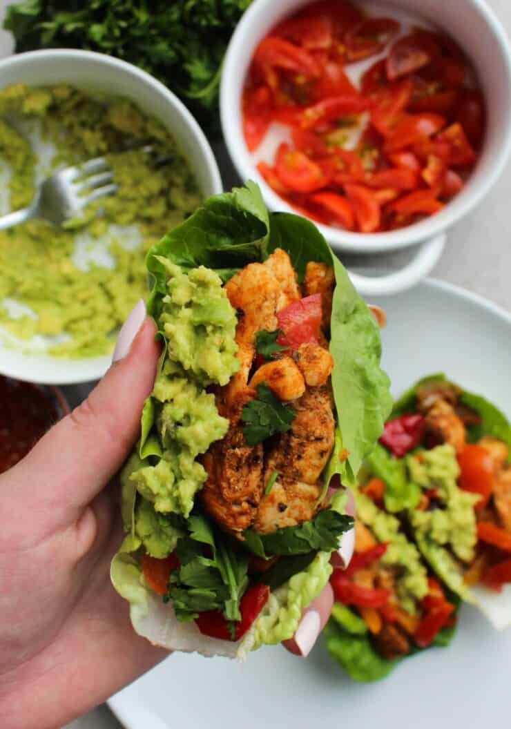lettuce leaves filled with chickens, chopped tomato and avocado