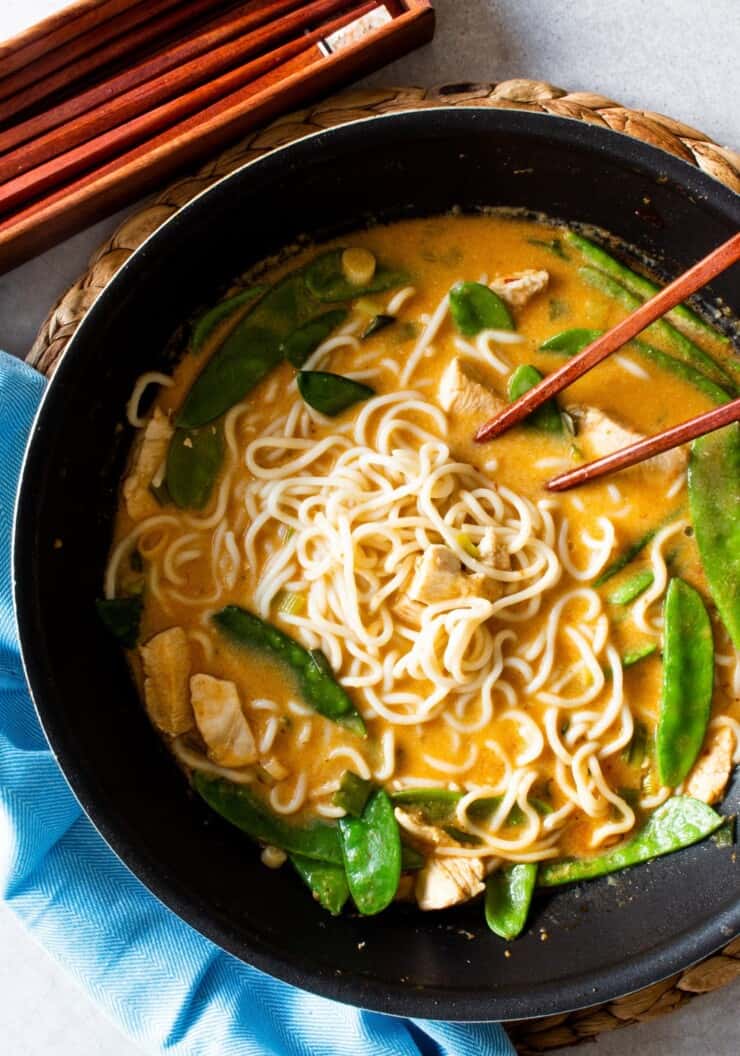 Chicken and noodles in sauce with mange tout in wok