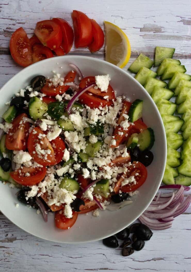 Overhead shot of Greek Salad with cucumber and tomatoes around plate