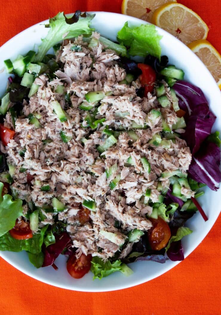 Tuna salad in bowl with lettuce, tomato and cucumber