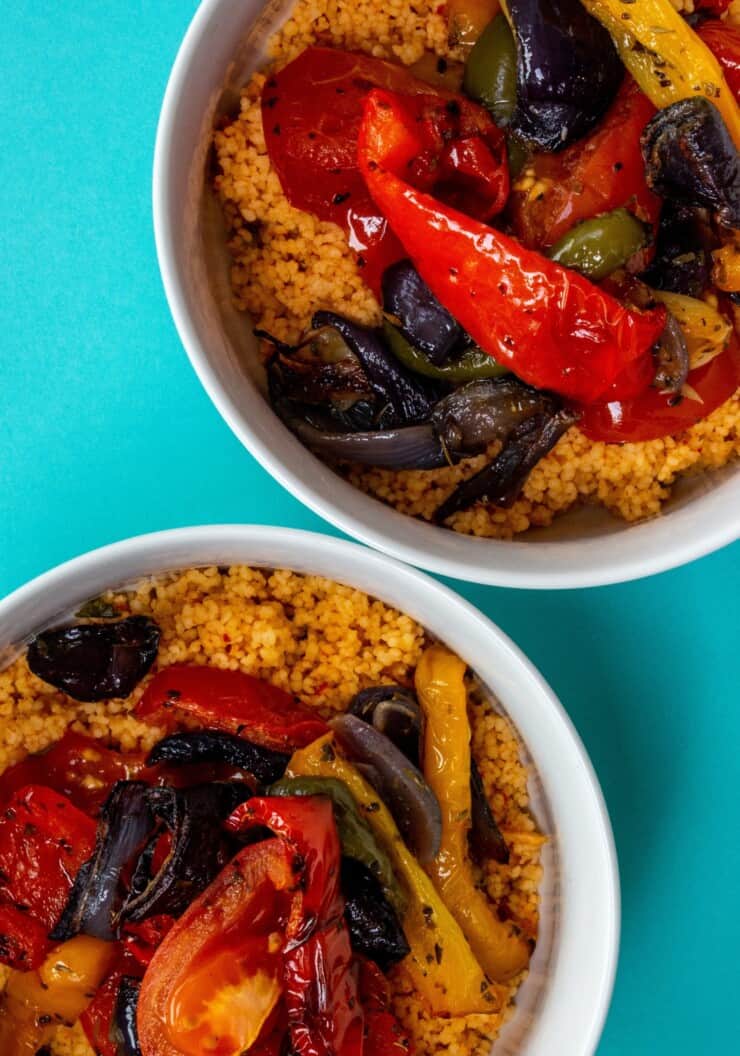 2 bowls of cous cous with roasted vegetables on top