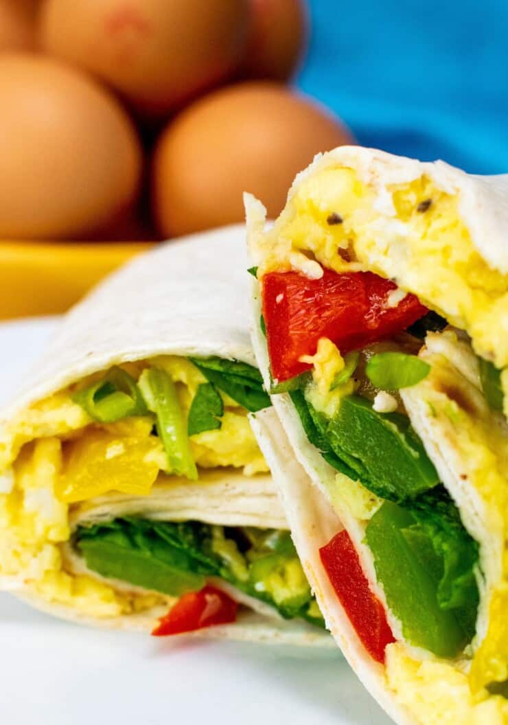Breakfast Burrito sliced in half with egg and salad