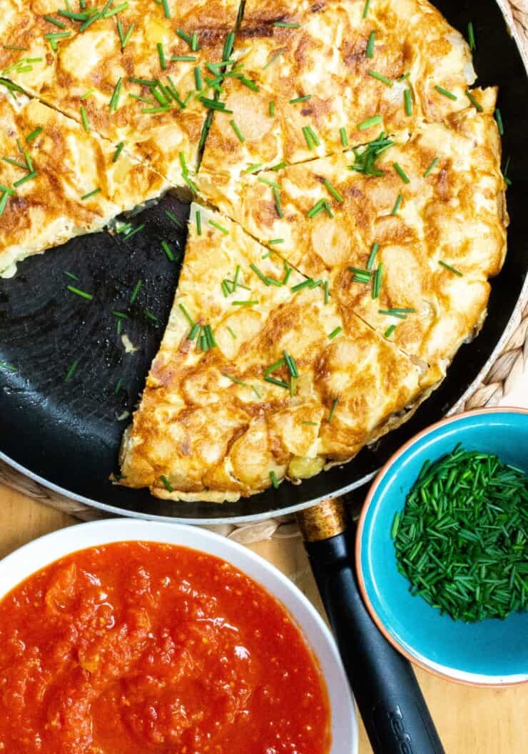 Overhead shot of tortilla with tomato sauce and chives