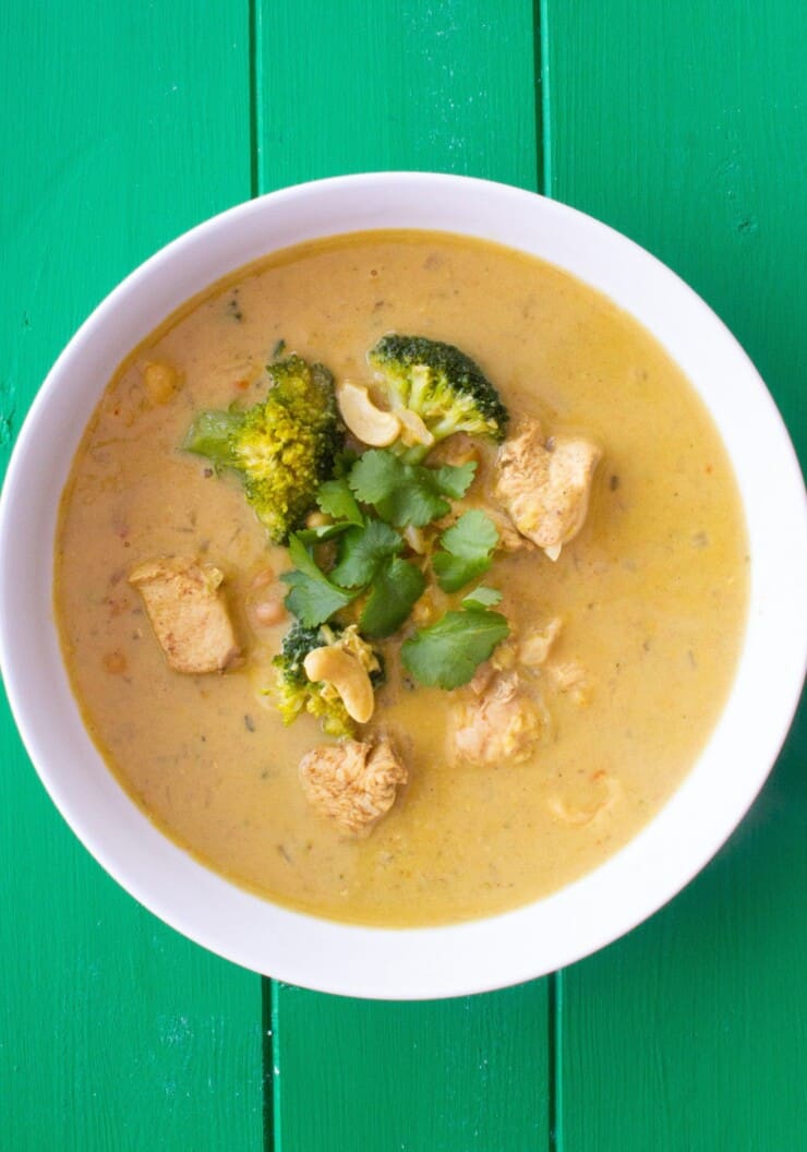 Overhead shot of bowl of chicken korma soup with broccoli and coriander topping