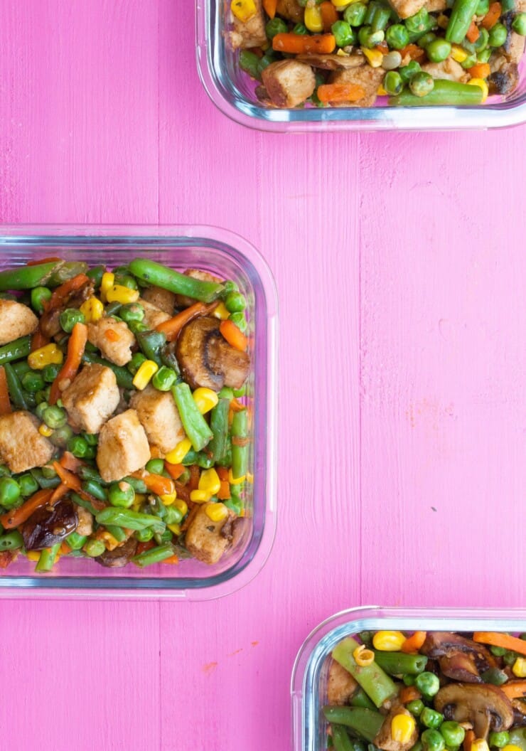 Overhead shot of glass meal prep containers filled with vegetable stir fry