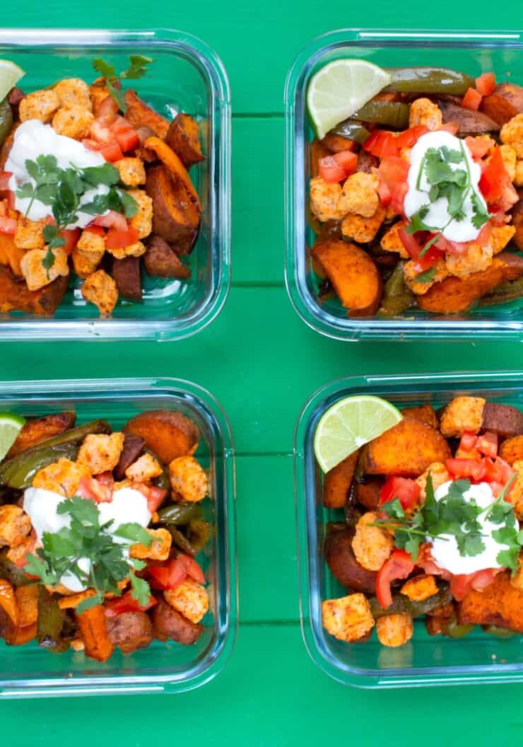 4 glass meal prep containers filled with sweet potatoes, quorn and vegetables garnished with wedge of lime