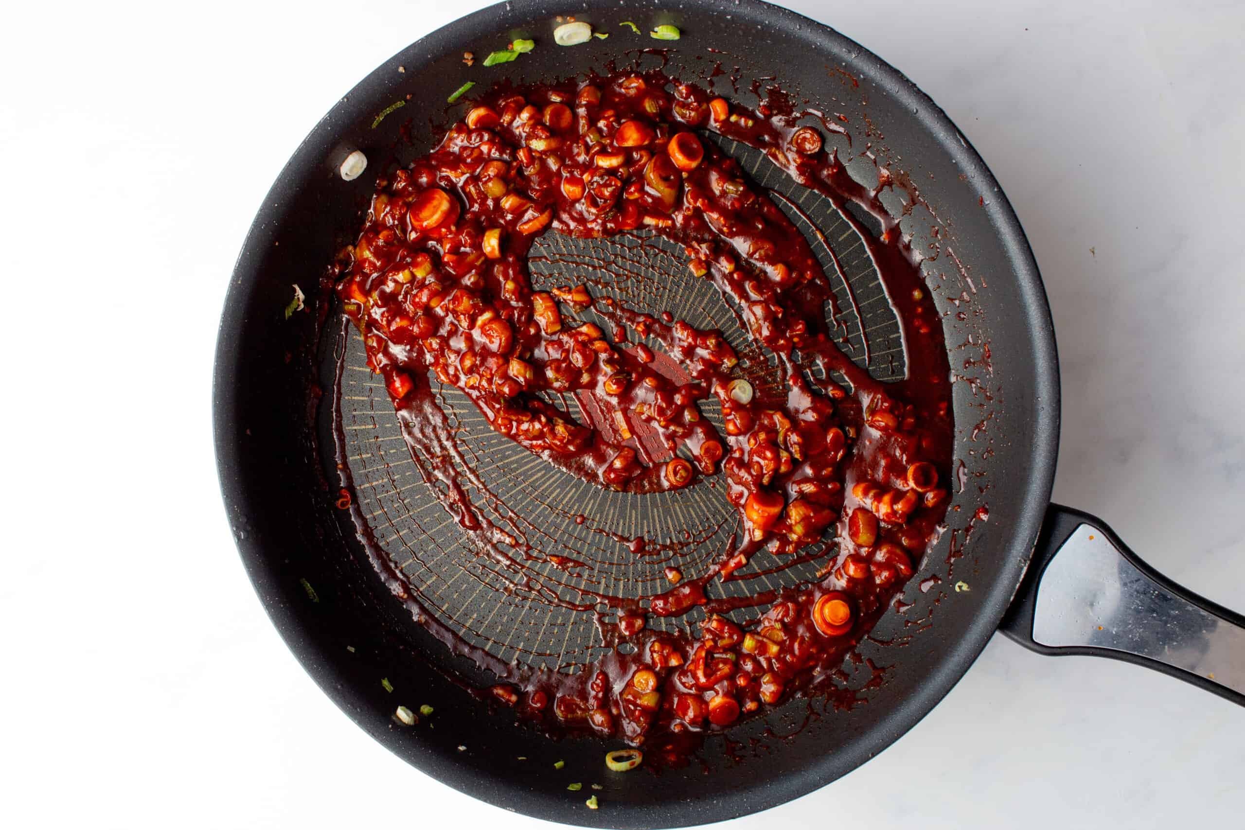Gochujang sauce added to the pan with garlic and spring onion.