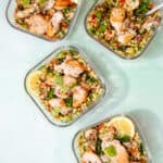 4 square glass meal prep containers with tabbouleh ginat cous cous salad with chicken.