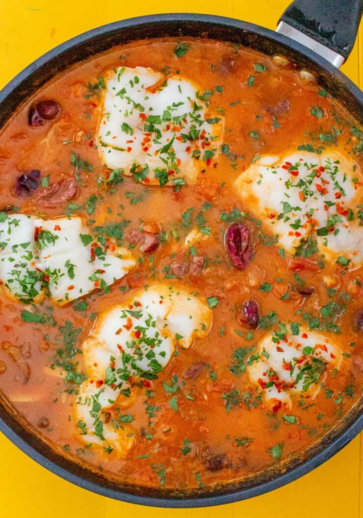 Overhead shot of haddock in tomato and garlic sauce in large pan