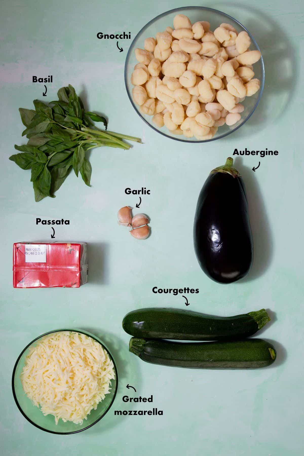 Ingredients to make gnocchi recipe laid out on a pale blue background and labelled.