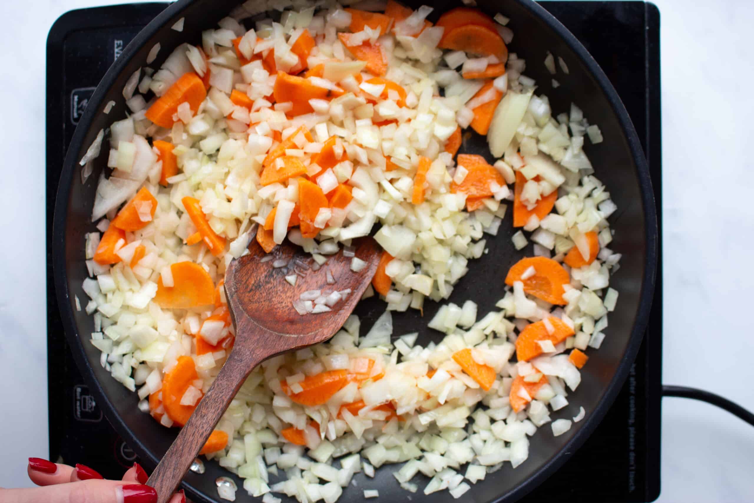 Carrot and onions in frying pan