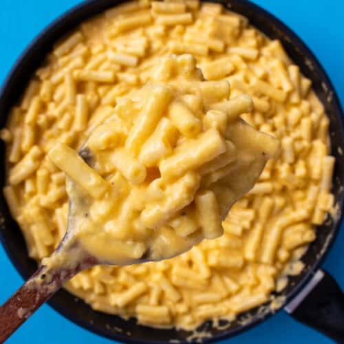 Overhead shot of large pan fun of creamy Mac and cheese with wooden spoon