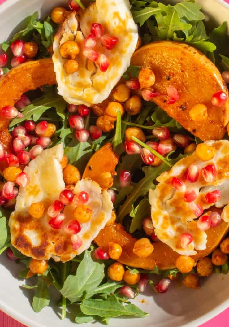 Pomegranate Halloumi Salad with roasted butternut squash on a bed of rocket.