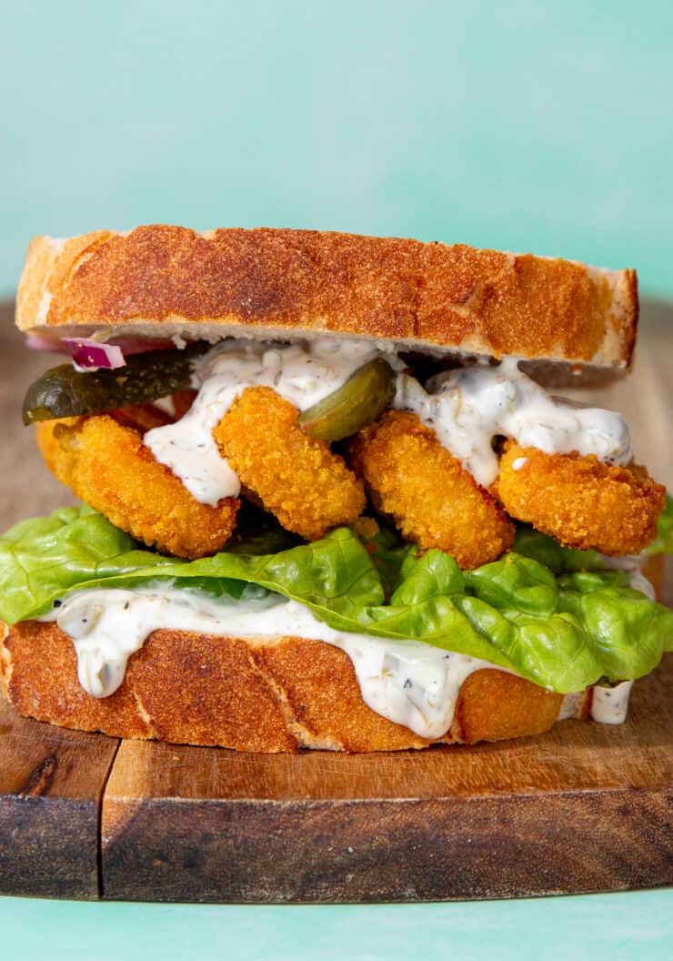 A fish finger sandwich with lettuce, mayo and gherkins.