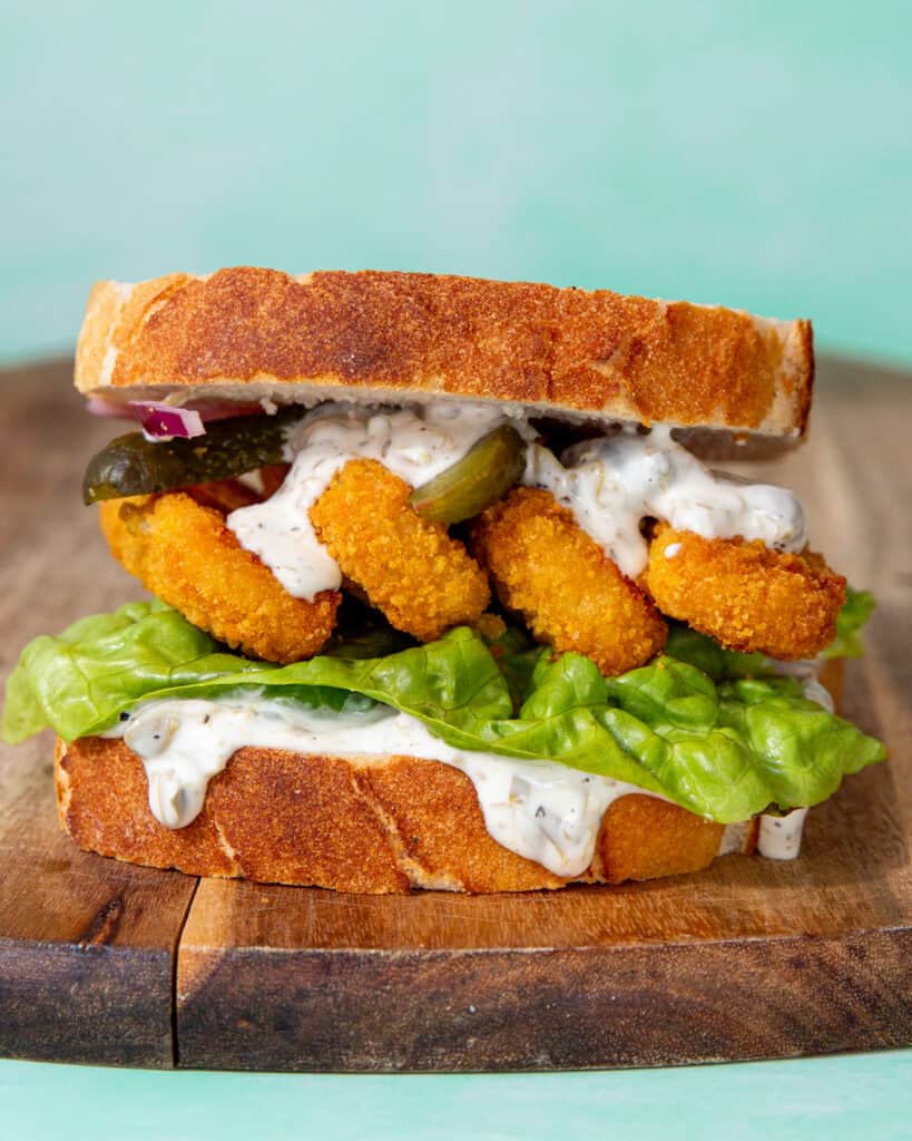 A fish finger sandwich with lettuce, mayo and gherkins.