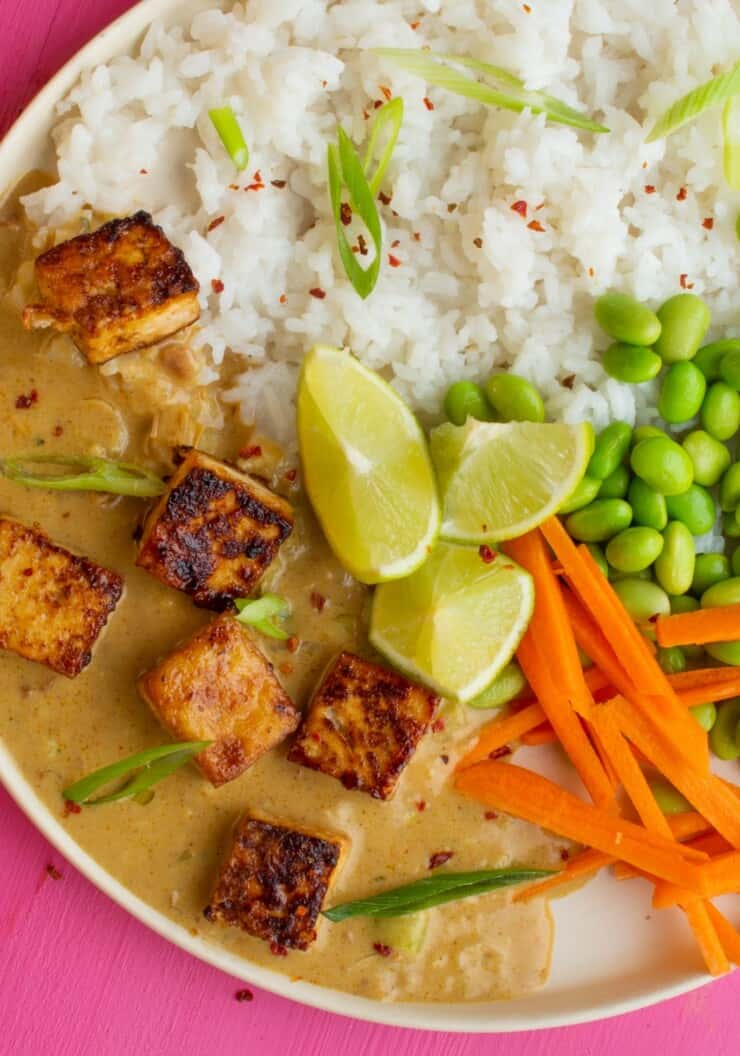 Crispy Tofu with Satay Sauce rice, edamame beans, carrots and lime wedges.