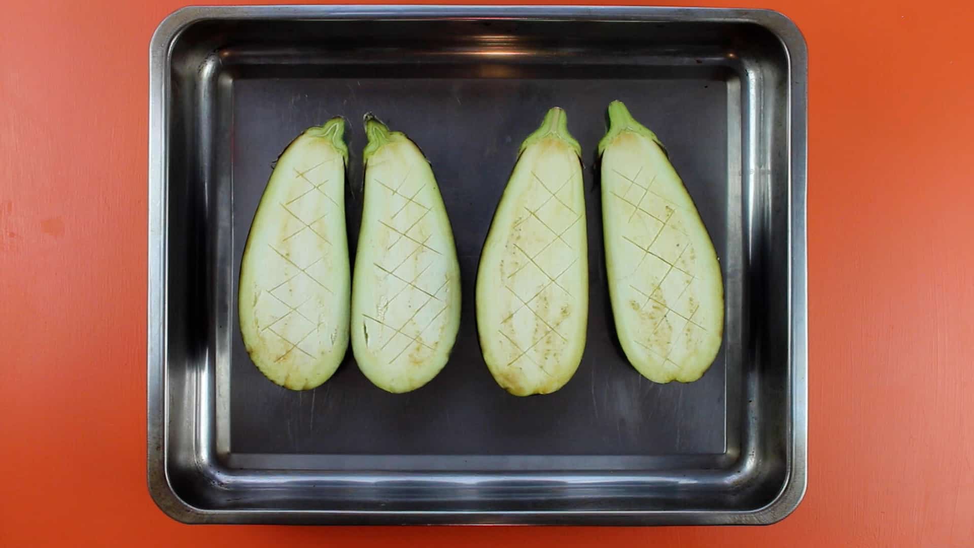 2 aubergines cut in half and scored on baking tray
