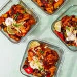 4 square glass meal containers with Low Carb Mexican Inspired Chicken with broccoli, peppers, red onion with sour cream, cheese and limes.