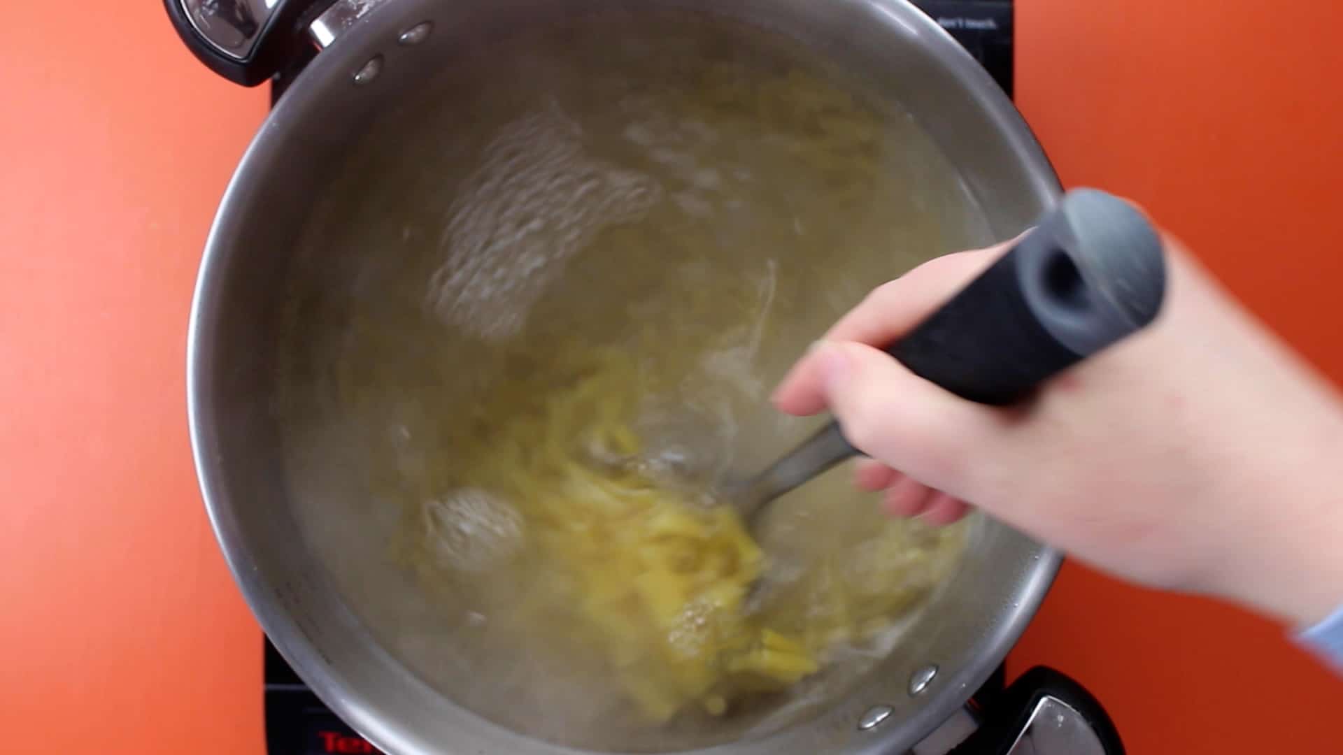 Pasta in boiling water being stirred