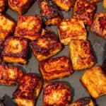 Close up of cubes of tofu browned and crispy in a pan.