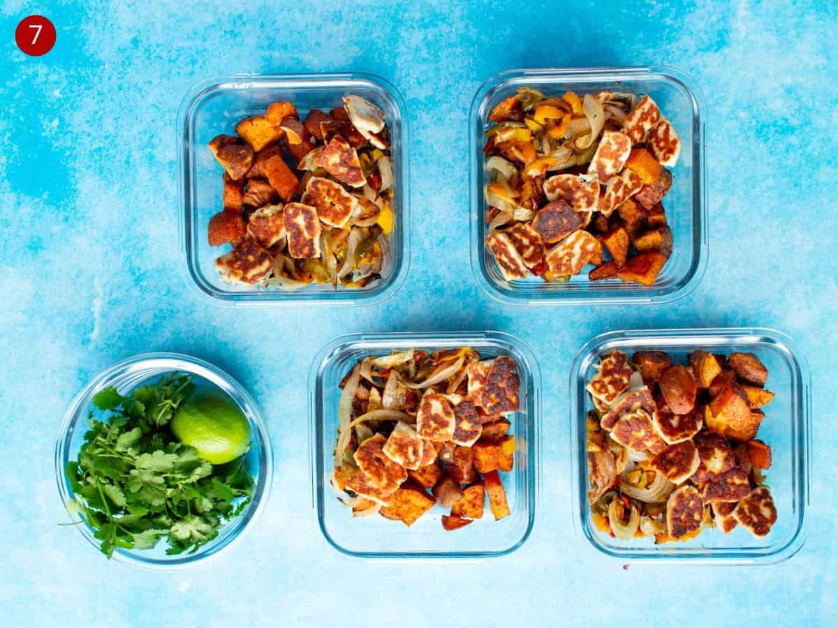 4 square glass meal prep containers with baked sweet potato chunks, roasted peppers and golden browned halloumi, a round bowl with lime and coriander on blue background.