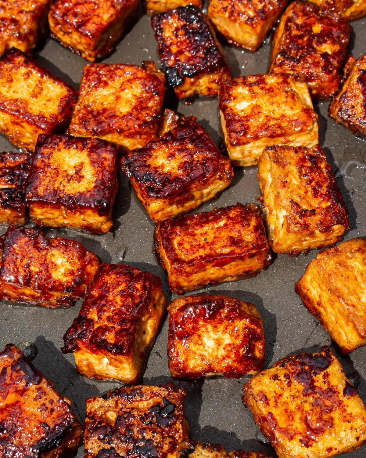 Golden browned tofu close up shot in frying pan