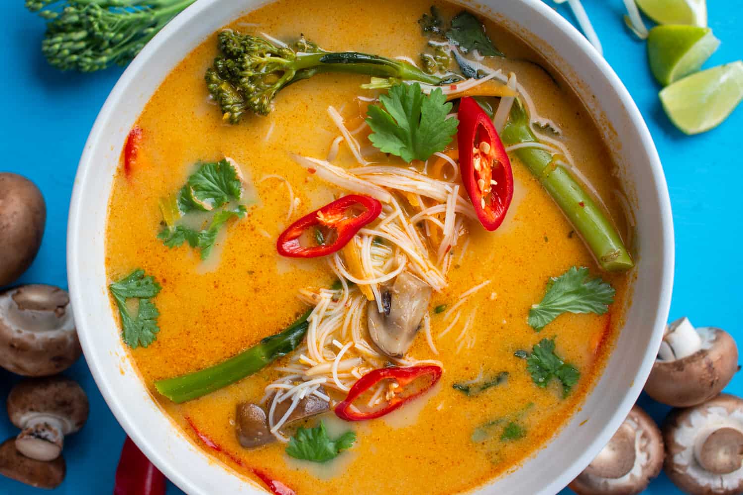 creamy spiced ramen topped with chillies. Vegetables decoratively placed around the bowl