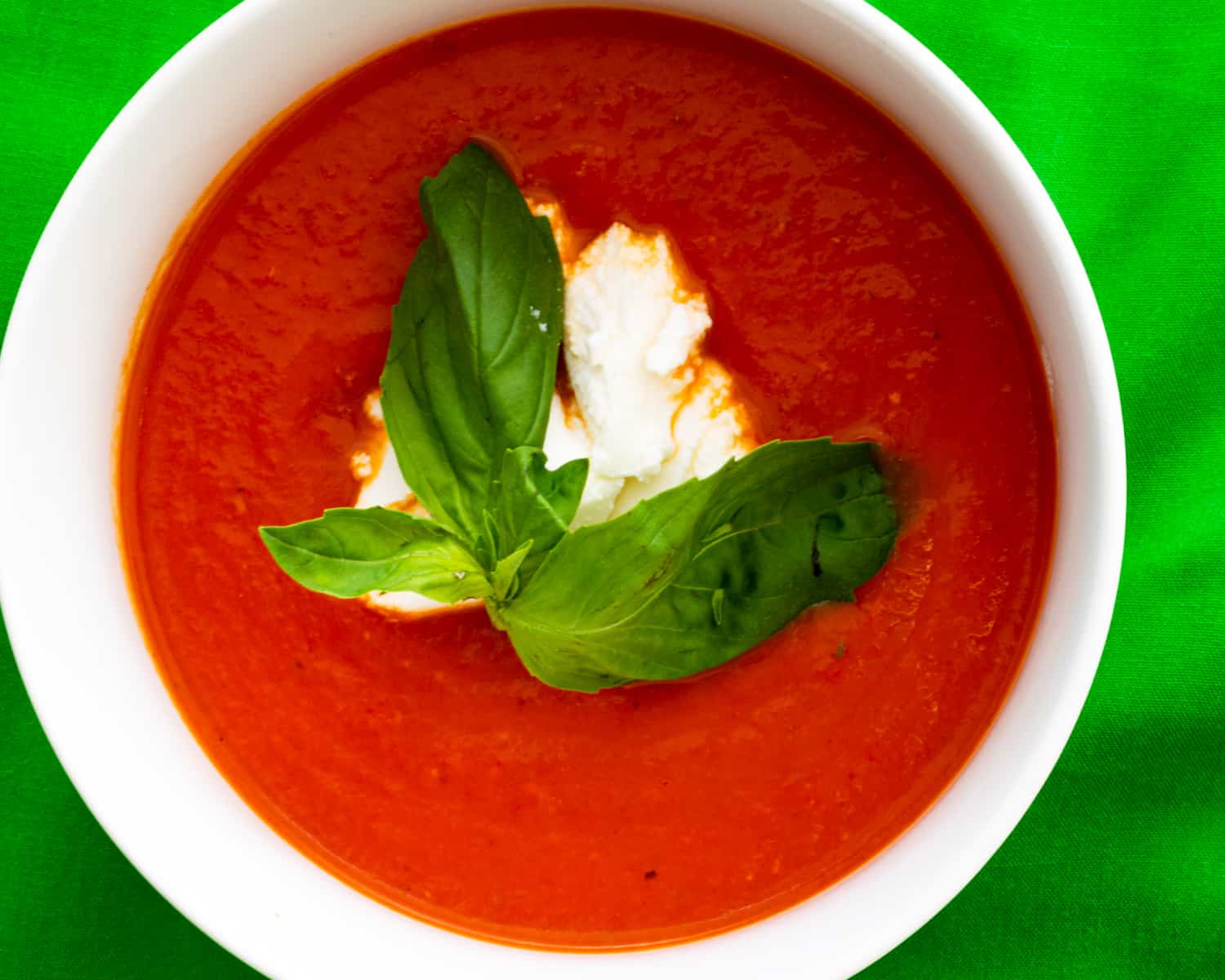tomato soup topped with basil and ricotta