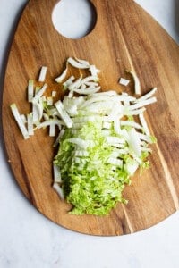 Sliced Chinese cabbage in a wooden chopping board.