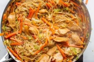 Chicken added to the cooked Vermicelli noodles in the large stainless steel pan.
