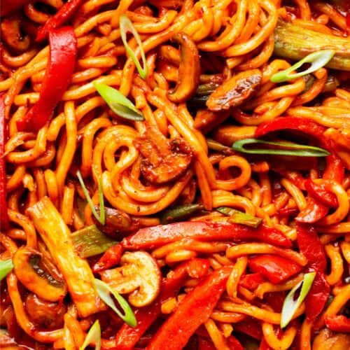 Close up of noodles in tomatoey sauce with vegetables.