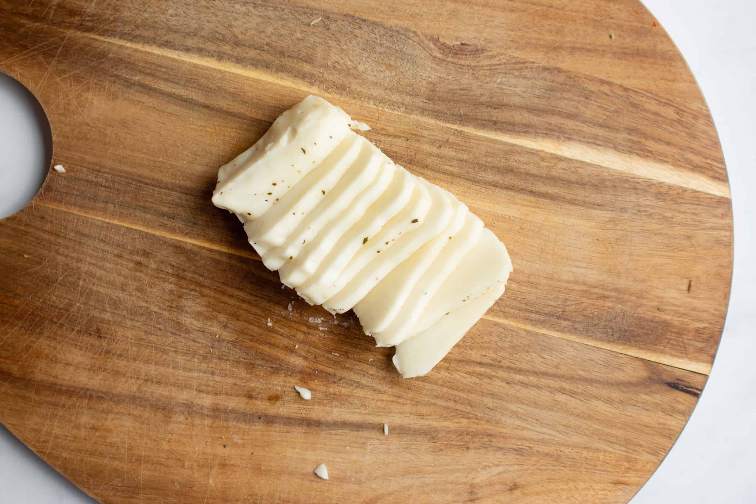 Halloumi sliced on wooden chopping board