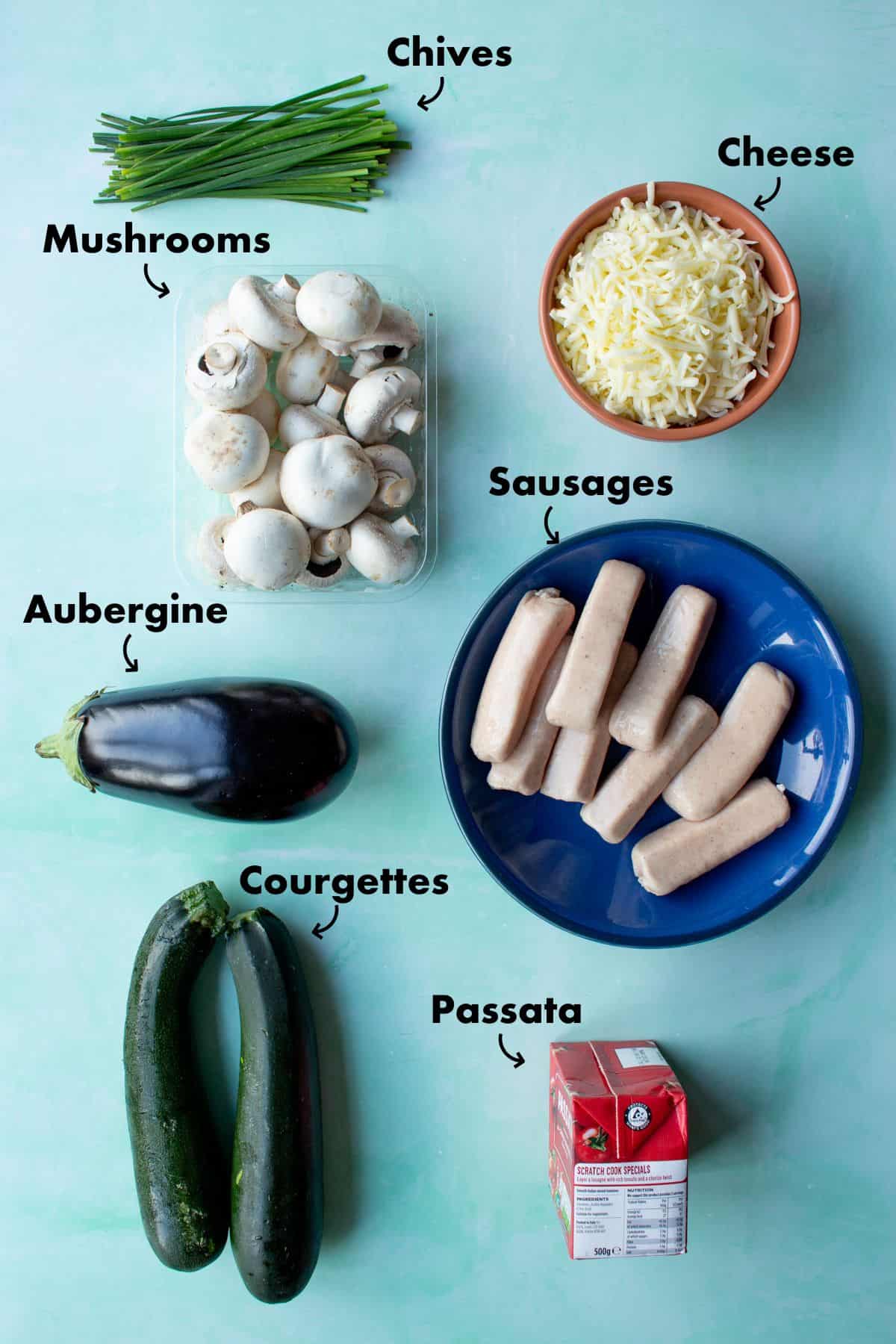 Ingredients to make Crustless Pizza Bowl laid out on a pale blue background and labelled.