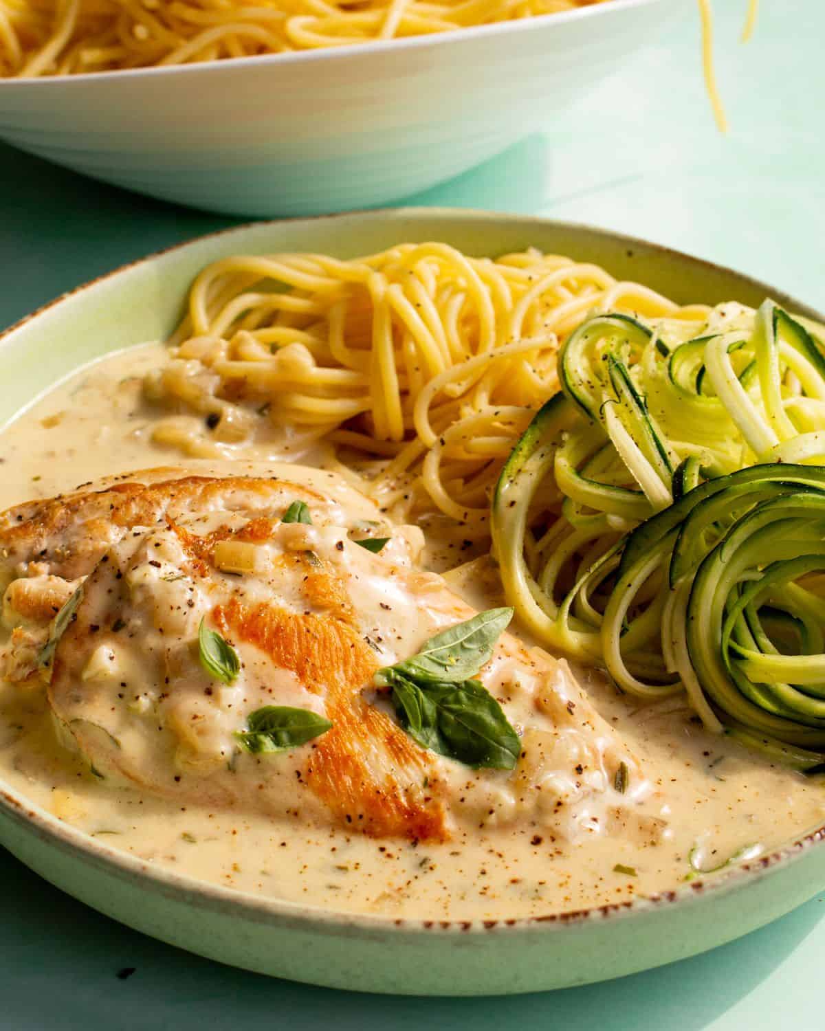 Creamy Philadelphia chicken served with spaghetti and spiralised courgettes and garnished with basil.