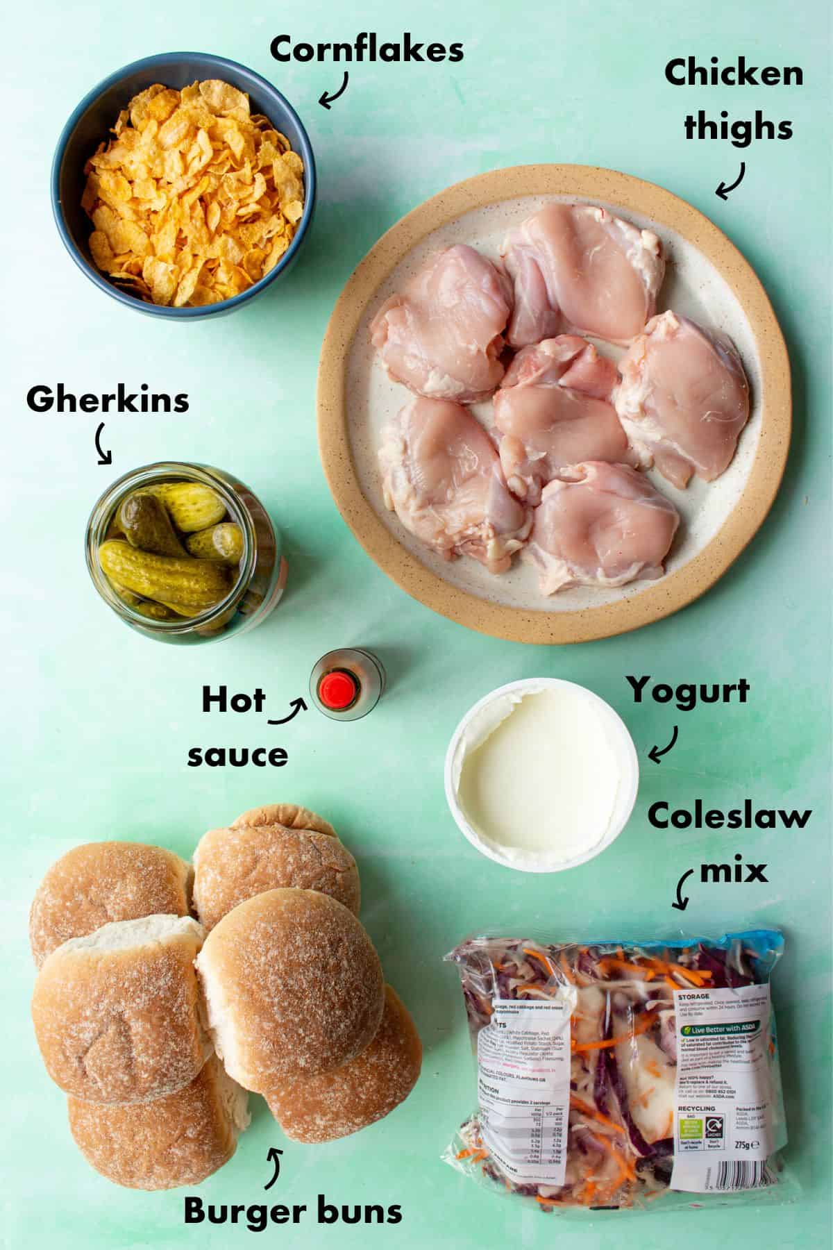 Ingredients to make the spicy chicken sandwich; cornflakes, chicken thighs, gherkins, hot sauce, yogurt and coleslaw.