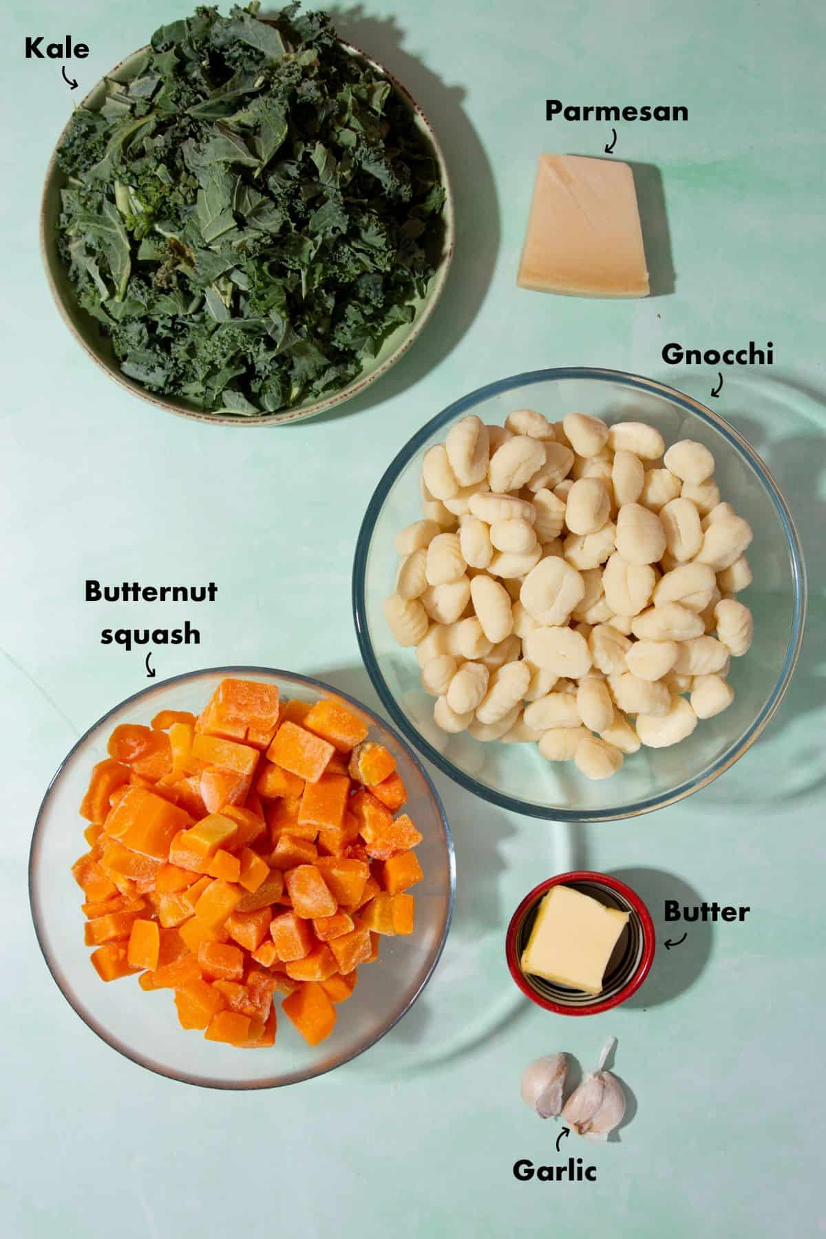 INgredients to make a gnocchi dish laid out on a plae blue back ground and labelled