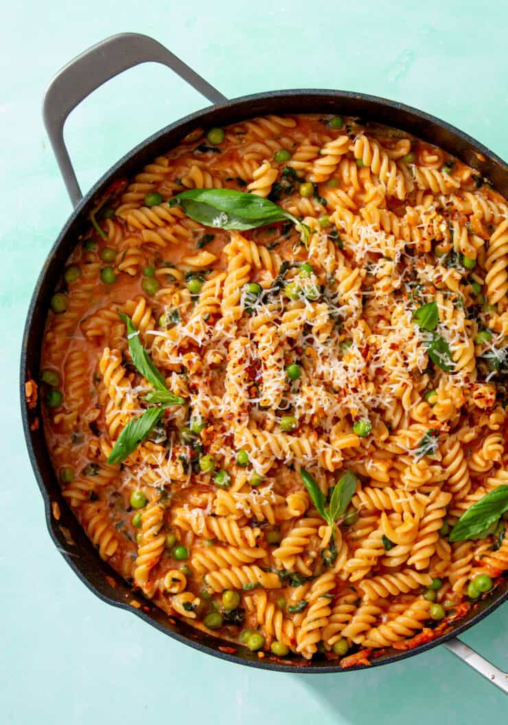Creamy Tomato & Spinach One Pot Pasta in a large pan garnished with fresh basil.