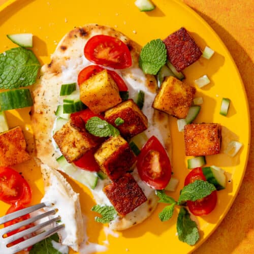 Crispy Fried Paneer with Naan served with cherry tomatoes, cucumber, mint and yogurt.