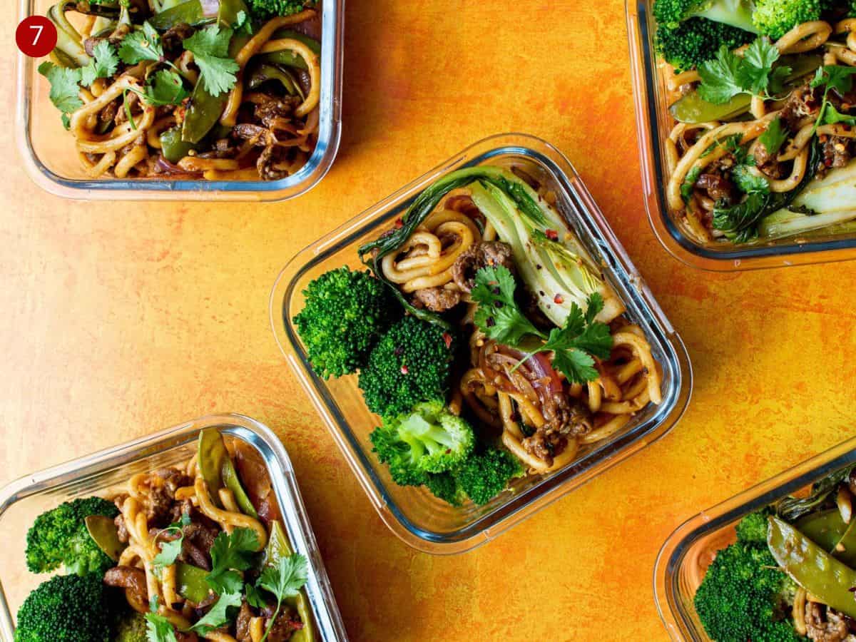 5 Meal prep dishes with beef ramen and broccoli on orange background.