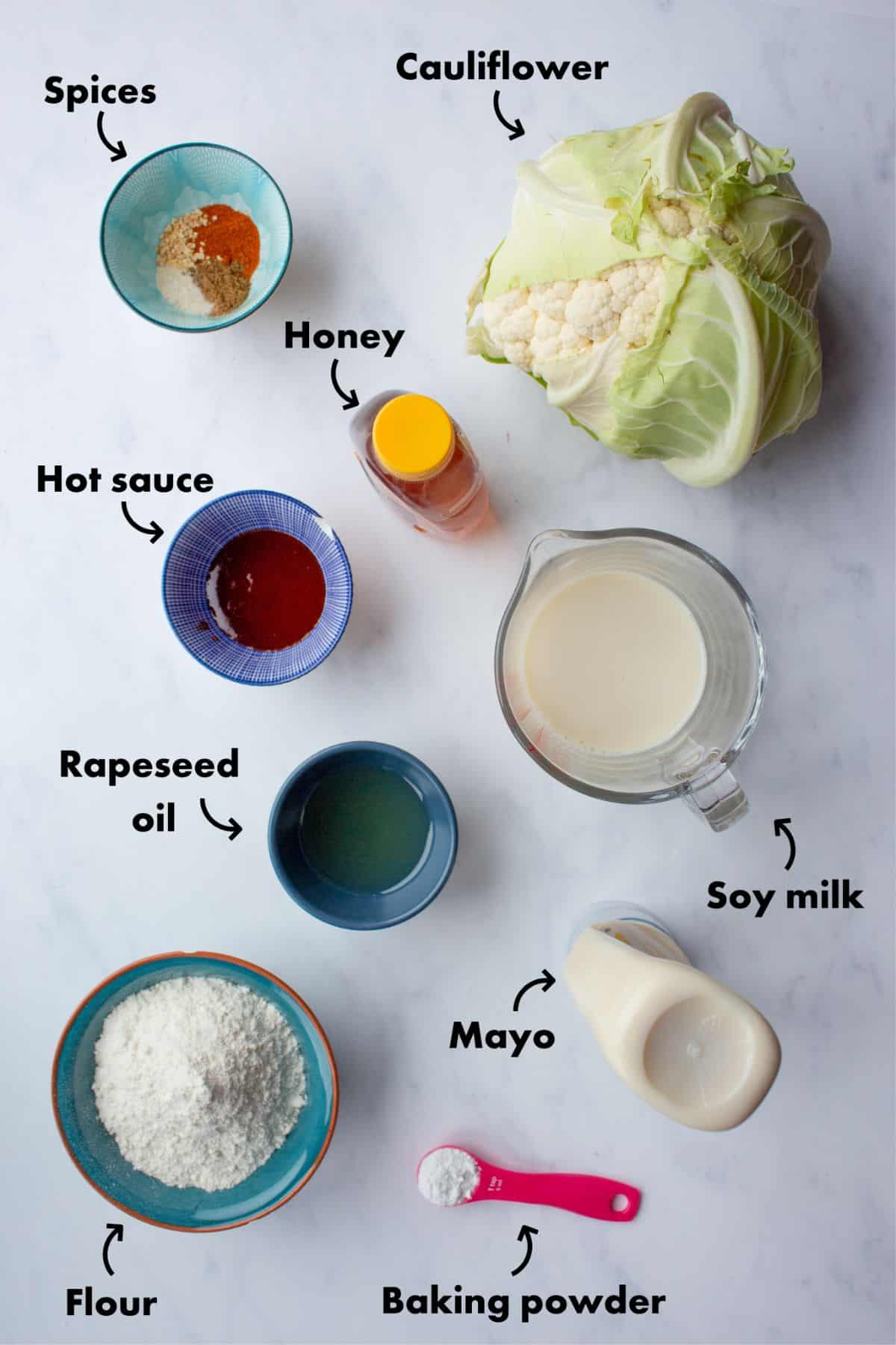 Ingredients to make Cauliflower bites laid out on a pale grey background and labelled.