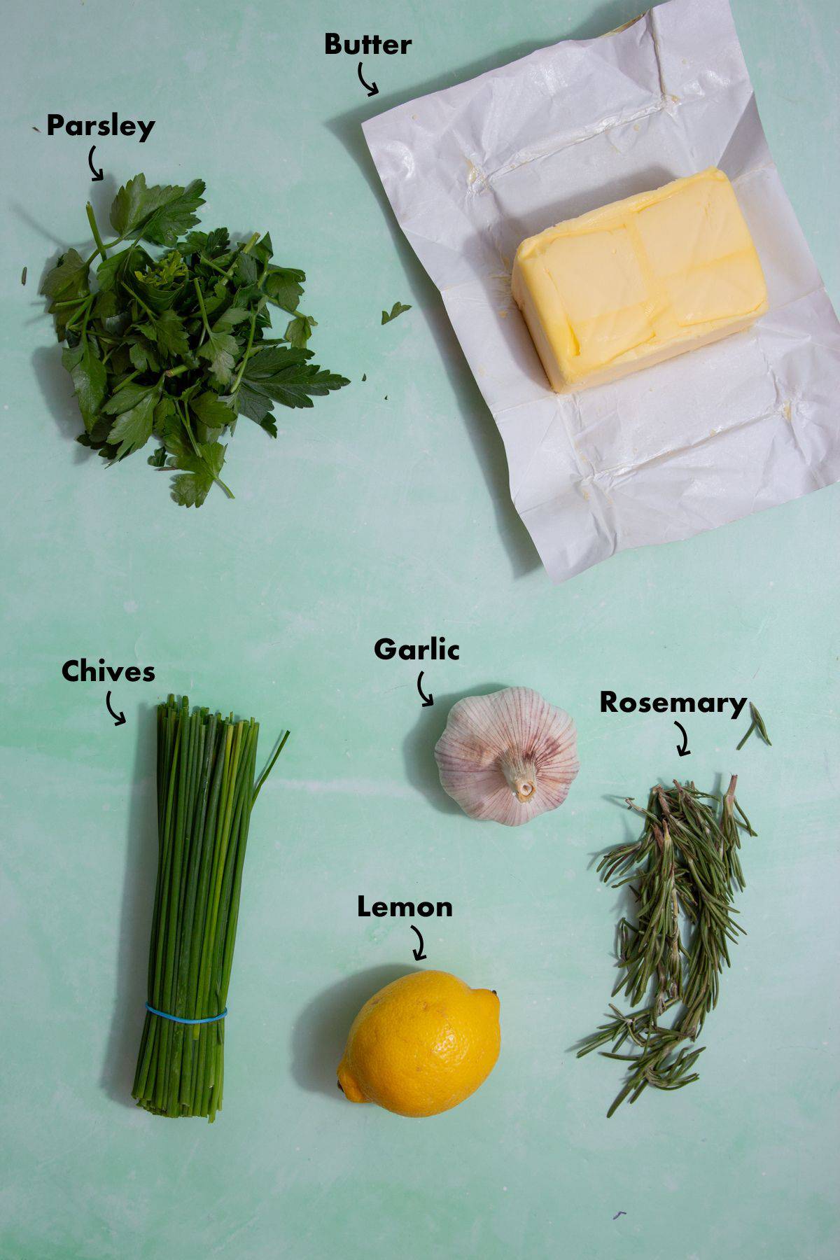 Ingredients laid out on a pale blue background to make the butter and herbs.