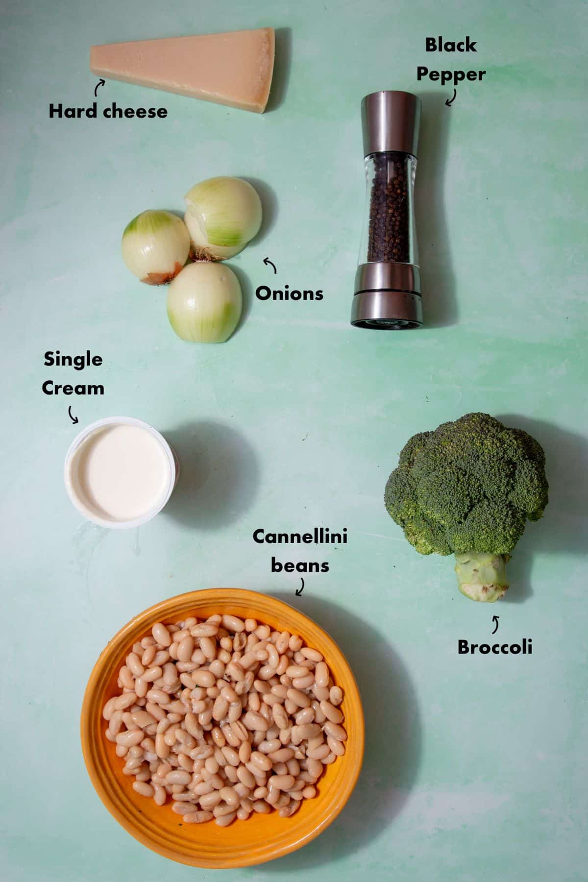 Ingredients to make the cannellini bean recipe laid out on a pale blue background and labelled.