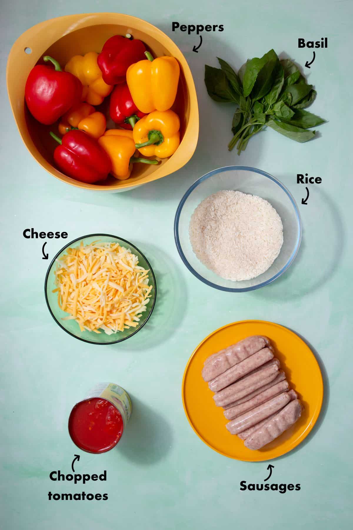 Ingredients to make stuffed peppers laid out on a pale blue background and labelled.