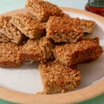 A plate full of flapjack squared piled on top of each other.