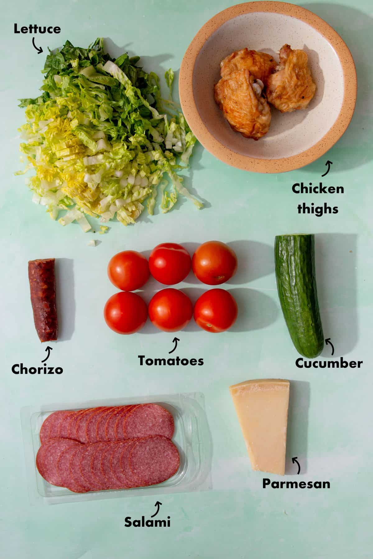 Ingredients to make a salad laid out on a pale blue background and labelled.