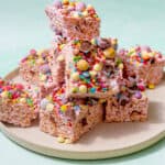 Lots of rice krispies with marshmallow squares decorated with broken and whole Easter eggs piled on a plate.