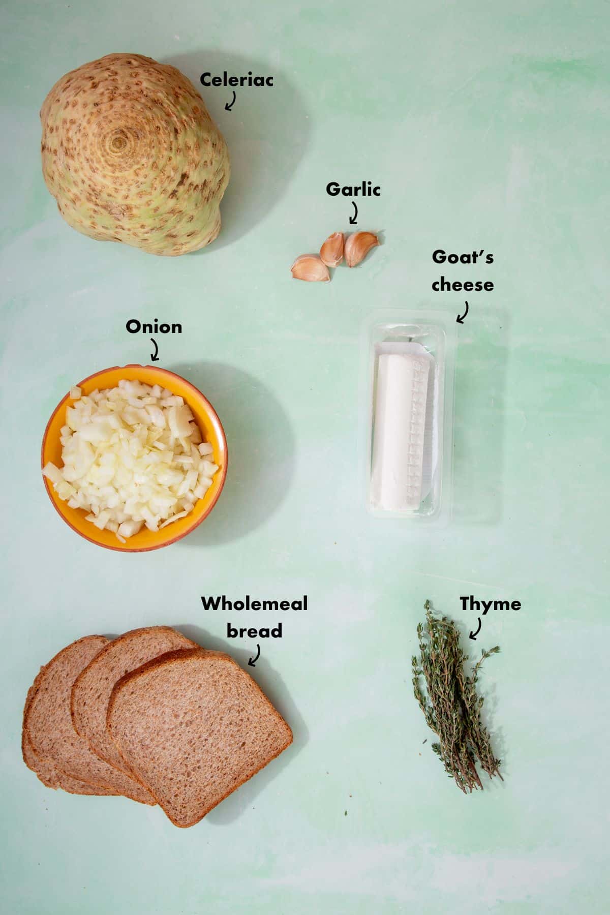 Ingredients to make celeriac soup, laid out on a pale blue background and labelled.