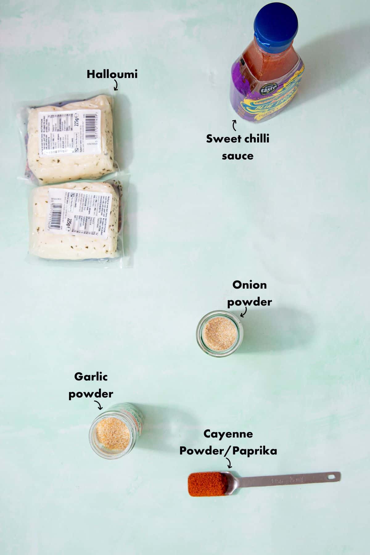 Ingredients to make the halloumi recipe laid out on a pale blue background and labelled.
