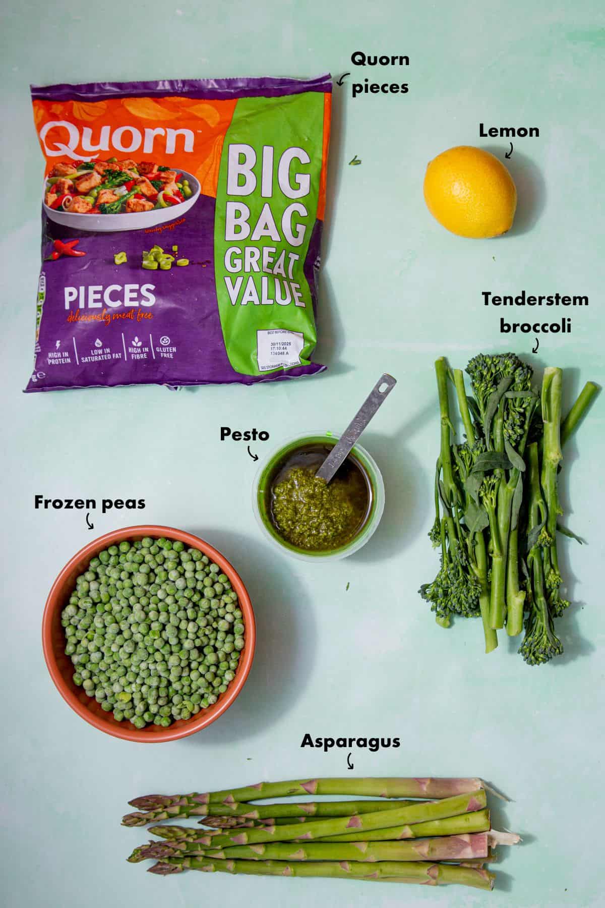 A bag with Quorn pieces and ingredients laid out of a pale blue background and labelled.