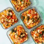 5 square glass meal pprep containers with orzo pasta salad with halloumi topped with some dill.